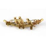 A 9ct yellow gold brooch depicting three birds in a branch, L. 4.5cm.