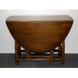 An oval oak drop leaf dining table, W. 100cm.