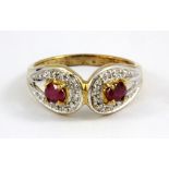 A 9ct yellow gold ring set with two oval cut rubies and diamonds, (L.5).