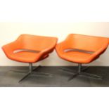 A pair of 1970's chrome and orange leather swivel armchairs, W. 84cm H. 68cm.