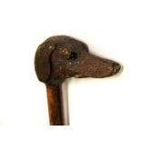 An early riding crop with wooden dogs head handle and glass eyes, L. 62cm.