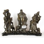 A Chinese carved soapstone group of three figures (Fu, Lou, Shou) on a carved wooden base, H. 22cm