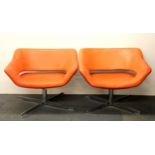 A pair of 1970's chrome and orange leather swivel armchairs, W. 84cm H. 68cm.