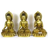 A set of three Sino-Tibetan gilt bronze figures of the seated Buddha, H. 30cm.