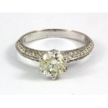 An 18ct white gold (stamped 750) solitaire ring set with a brilliant cut diamond and diamond set