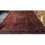A very large red ground handwoven Turkish wool carpet, size 410 x 309cm.
