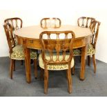 A superb painted satinwood extending circular dining table and six chairs with a complete set of