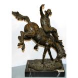 A bronze figure of a rodeo rider on a marble base after Frederic Remington, H. 48cm.