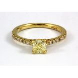 An 18ct yellow gold solitaire ring set with a 0.61ct cushion modified brilliant cut natural fancy