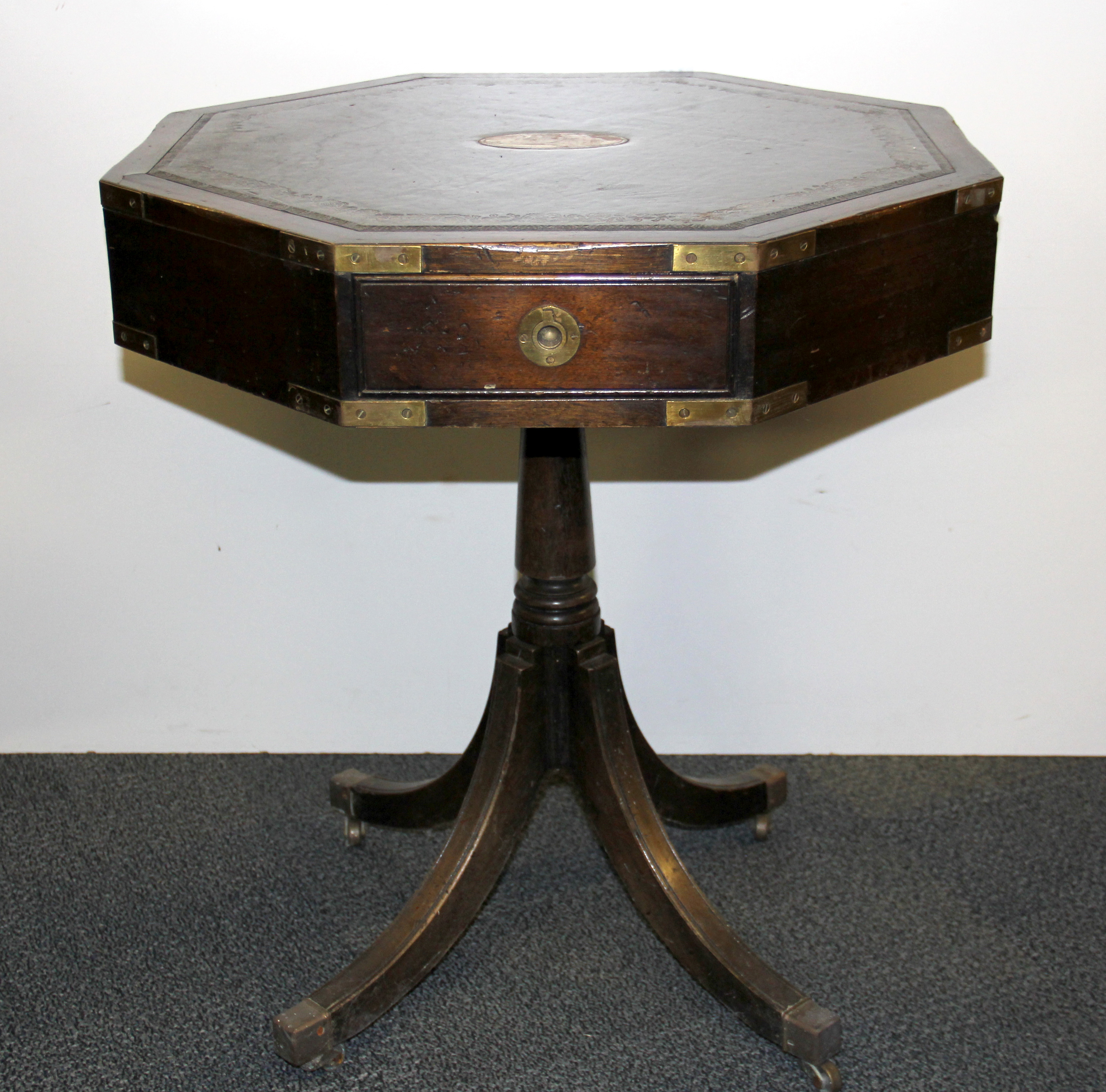 A leather topped brass mounted revolving table, W. 60cm H. 67cm.