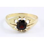 A 9ct yellow gold ring set with a round cut garnet, (W.5).