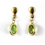 A pair of 9ct yellow gold (stamped 9ct) peridot set drop earrings, L. 1.9cm.