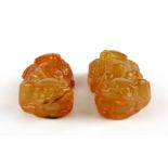 A pair of Chinese carved amber coloured agate liondog amulets, L. 4.5cm.
