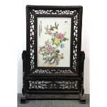 A Chinese hand painted porcelain panel in a carved wooden table screen frame, overall H. 67cm W.