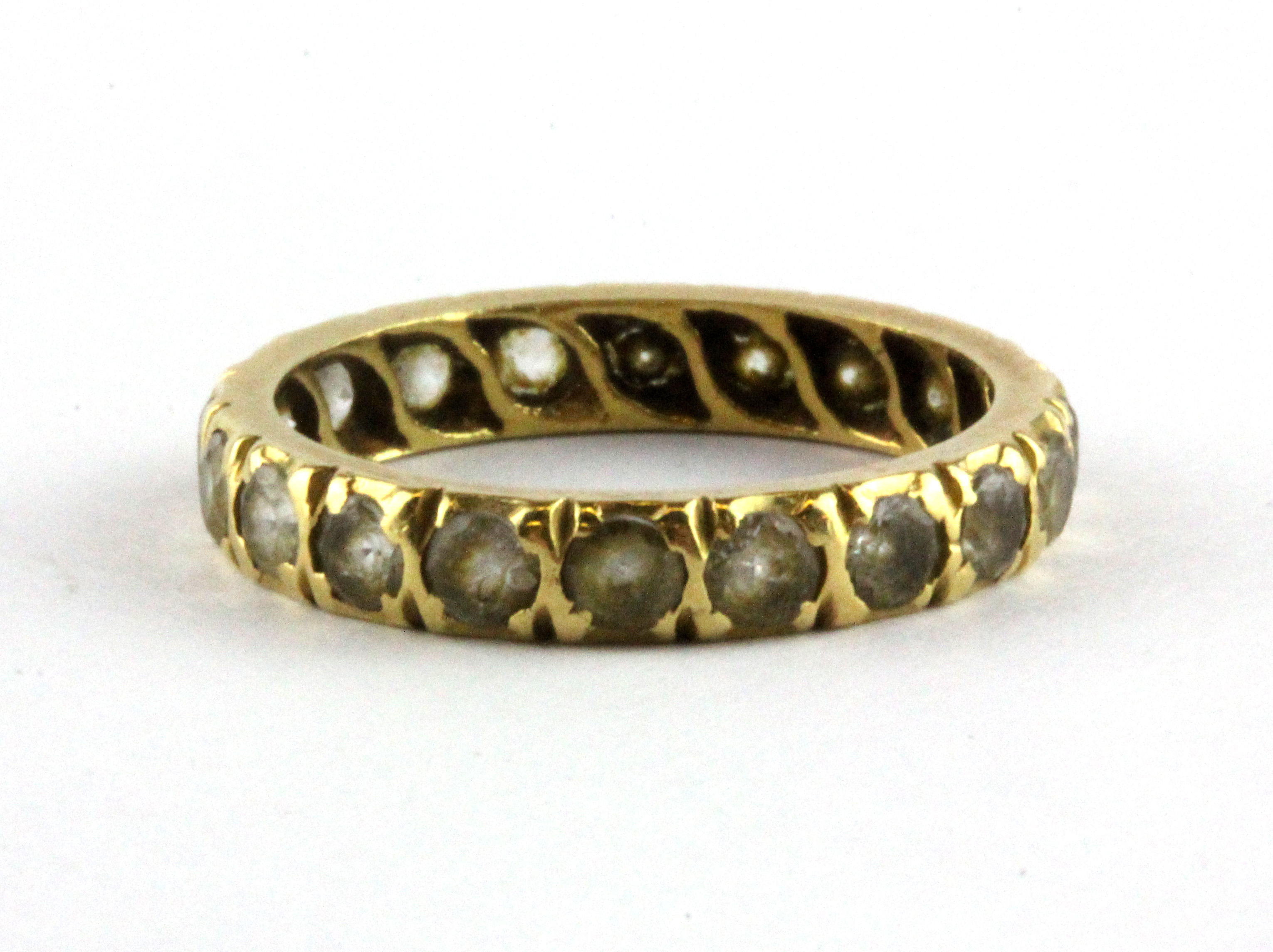 A yellow metal (tested minimum 9ct gold) stone set full eternity ring, (L).