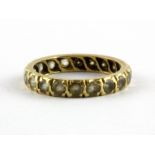 A yellow metal (tested minimum 9ct gold) stone set full eternity ring, (L).