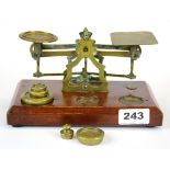 A mahogany and brass post office scale and weights.