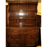 A carved oak dresser, W. 130cm H. 193cm.