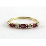 A 9ct yellow gold half eternity ring set with marquise cut rubies and white stones, (O).