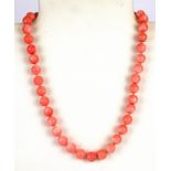 A single strand necklace of 9.5mm polished coral beads.