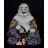 A hand enemalled porcelain figure of the seated happy Buddha, H. 19cm.