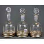 Three 19th Century etched glass decanters for port, sherry and claret with silver plated coasters,