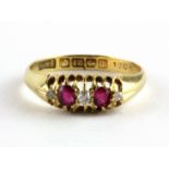 An 18ct yellow gold ring set with oval cut rubies and diamonds, (K.5).