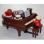 An amusing musical teddy bear at a piano, W. 24cm.