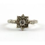 A hallmarked 18ct white gold diamond set cluster ring with diamond set shoulders, (O).