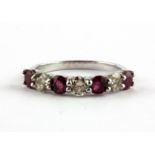 An 18ct white gold (stamped 750) half eternity ring set with brilliant cut rubies and diamonds, (