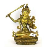 A Tibetan gilt bronze figure of a seated Tara with hand painted face, H. 27cm.