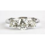An 18ct white gold (stamped 750) ring set with three brilliant cut diamonds, approx. 1.16ct centre