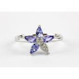 A 925 silver flower shaped ring set with marquise cut tanzanites, (P.5).