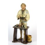 A Japanese pottery figure of a street food vendor H. 38cm.