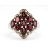 A 925 silver cluster ring set with oval cut rhodolite garnets, (Q).