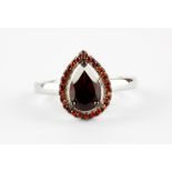 A 925 silver cluster ring set with a pear cut garnet surrounded by round cut orange sapphires, (L).