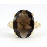 A 9ct yellow gold ring set with an oval cut smokey quartz, (R.5).