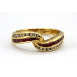 An 18ct yellow gold crossover ring set with baguette cut rubies and brilliant cut diamonds, (N).