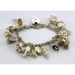 A hallmarked silver bracelet with silver and other white metal charms.