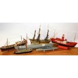 A group of five plastic and one wooden kit models of a submarine and boats.