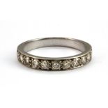 A white metal (tested 18ct gold) diamond set half eternity ring, (N).