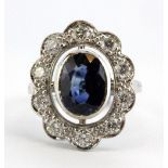 An 18ct white gold (stamped 18k) large cluster ring set with an oval sapphire and diamonds,