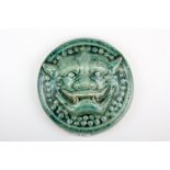 A green glazed Chinese terracotta wall plaque depicting a demon face, Dia. 21cm.