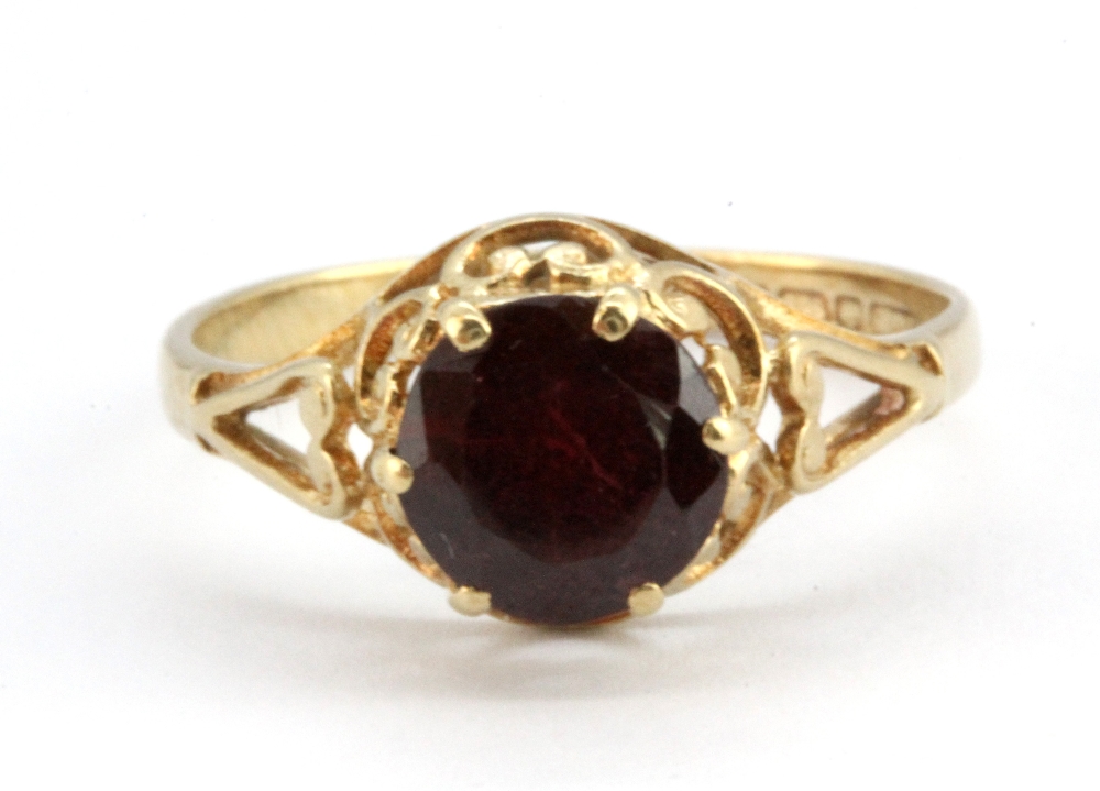 A 9ct yellow gold ring set with a swiss cut garnet, (N).