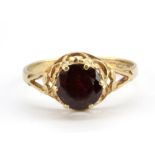 A 9ct yellow gold ring set with a swiss cut garnet, (N).