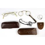 An early cased gilt metal and tortoise shell lorgnette, a cased pair of spectacles and a cased