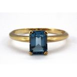A 9ct yellow gold ring set with an emerald cut topaz, (O).