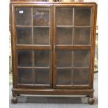 A 1930's oak bookcase, H. 110cm W. 85cm D. 23cm.