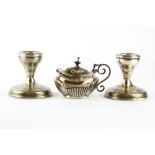 A pair of small hallmarked silver candlesticks and a silver mustard pot.