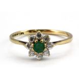 A 9ct yellow gold emerald and white stone set cluster ring, (P).